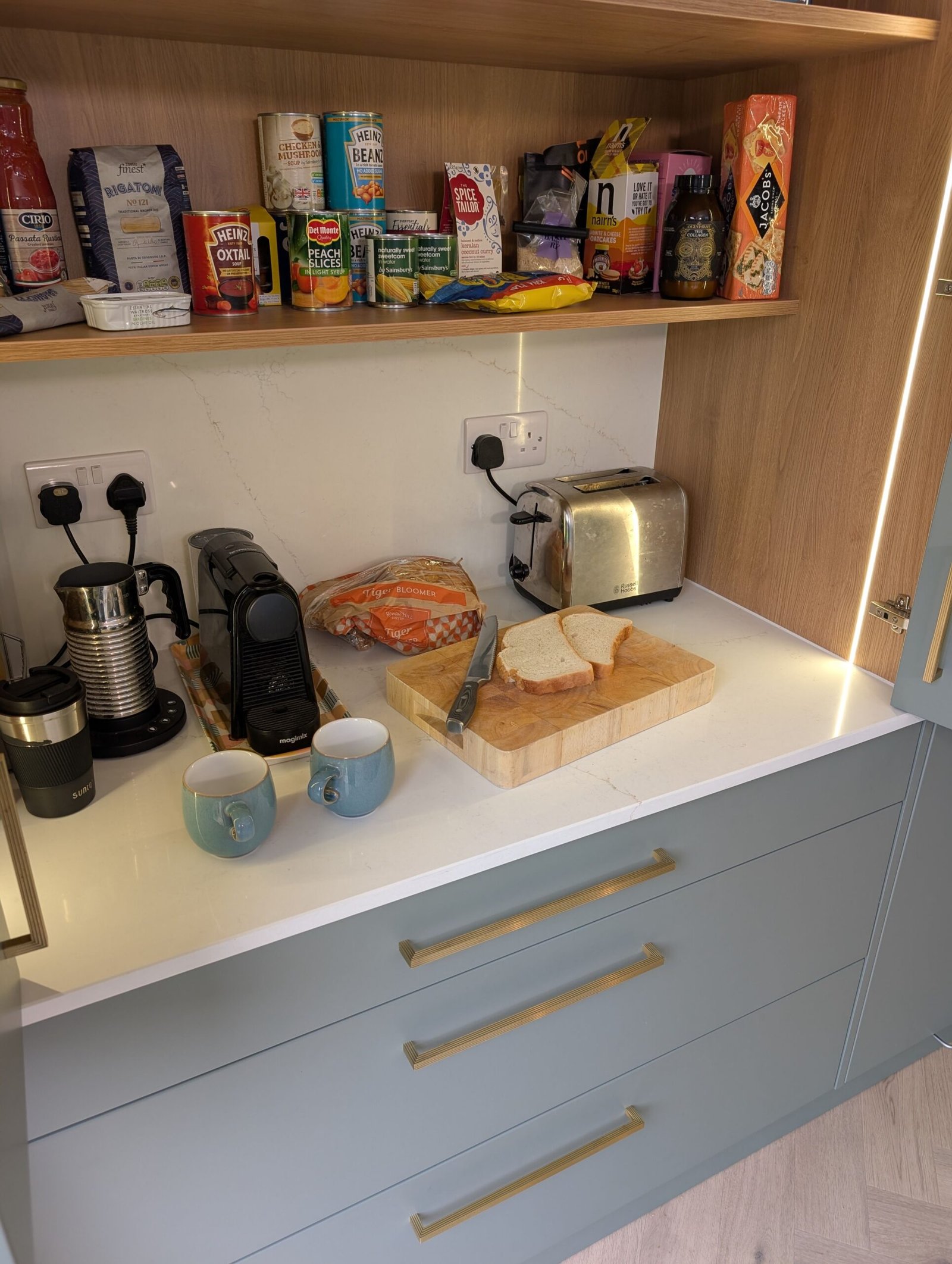 Avorio Trace quartz worktop inside a larder cupboard with oak shelves, a coffee machine and a toaster