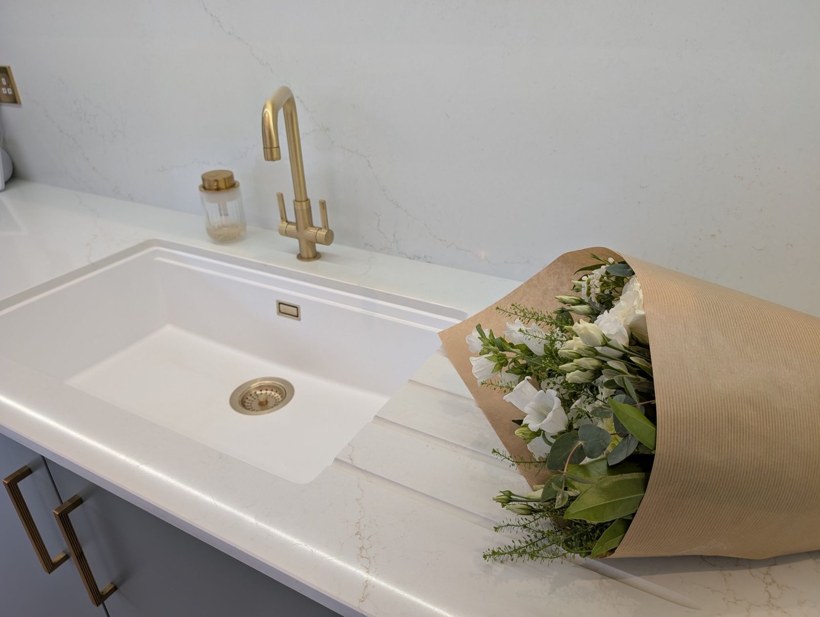 White Schock undermount sink set into an Avorio Trace quartz worktop with a brushed brass tap