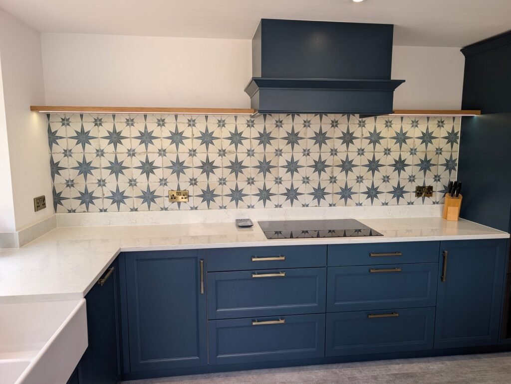 Navy shaker kitchen with Chalk Mist quartz worktop, induction hob, star tile splashback and matching extractor canopy