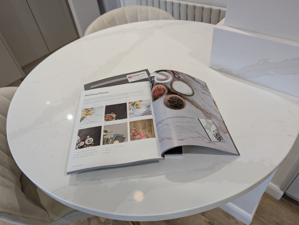 Teardrop breakfast table with a Gilded Vein quartz top beside a matching quartz upstand