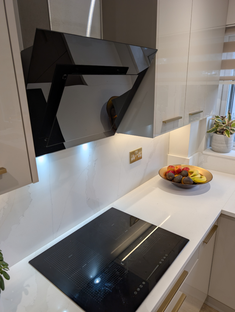 Close view of the Gilded Vein quartz splashback and worktop beneath an angled black glass extractor