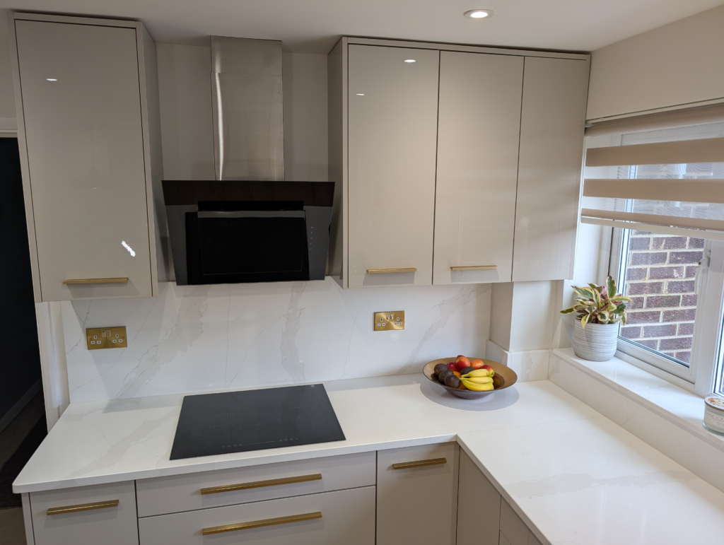 Induction hob on a Gilded Vein quartz worktop with a full-height quartz splashback and angled extractor